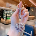 Close-up of heart-shaped rhinestone keychain with purple crystals and gold hardware - Purple
