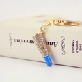 Sparkling lipstick keychain with blue resin and clear rhinestones on gold metal chain - Blue