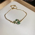 Detail of gold-plated flower bracelet with green heart elements and zircon inlay - Bracelet-Blue