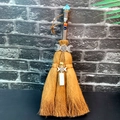 Close-up of decorative brown witch broom with natural crystals and moon charms - Labradorite + Triple Moon + White Turquoise