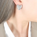Pendientes de corazón en oro de 18 quilates plateado con diseño escalonado en una modelo - Pendientes de Corazón / Color Acero