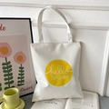 White Oxford tote bag featuring yellow hello SUNSHINE graphic on an open book - White with Hello Sunshine Circle