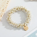 Detail of beaded hair tie with crystal pearls and gold HAND MADE charm on marble - White Crystal Style