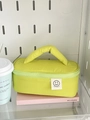 Detailweergave van groene gewatteerde make-uptas met smile-patch en zacht handvat - Groen