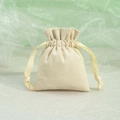 Single beige linen drawstring jewelry pouch on light green fabric background - Raw Cloth Ruffled Grosgrain Ribbon / 7*9cm