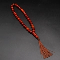 Handcrafted red agate prayer beads with a dark brown tassel on a black background - Red Agate
