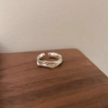 Minimalist silver open ring with irregular wave texture on a dark wood surface - JZ0741 (Irregular Ripple)