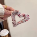 Gros plan sur une pince à cheveux cœur au crochet coloré avec texture en maille douce - Rayé rose