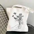 Minimalist wildflower garden canvas tote bag with black line art of hand holding flowers - C2 Handheld Flower Bouquet Line Art