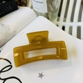 Detailed view of the large amber acrylic hair claw clip with its square hollow design - Autumn Yellow