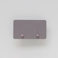 Macro shot of pink round-cut birthstone stud earrings in silver four-prong setting - October: Pink