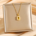 Luxuriöse Goldkette mit rechteckigem gelbem Edelsteinanhänger auf beiger Seide - Gold Gelb Zirkonia