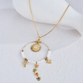 Bohemian gold chain necklace with sun pendant, white beads, and colorful charms - White