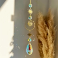 Golden sun and moon crystal suncatcher with teardrop prism creating rainbow reflections - Eye Sun Pattern Style