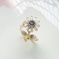 Detailed close-up of a rotating daisy flower and bee ring with sparkling crystals - 18K Gold Plated Blue Zirconia