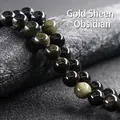 Macro shot of 10-12mm gold sheen obsidian beads with natural cat eye effect on a dark base - Gold Obsidian