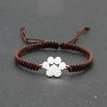 Close-up of adjustable brown woven rope bracelet with silver metal paw print charm - Dark Brown