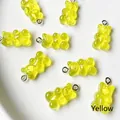 Gros plan de pendentifs ours jaunes en résine avec anneaux en argent pour bijoux artisanaux - Jaune