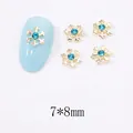 Détail du bijou d'ongle flocon de neige doré 7x8mm avec strass bleu mer et accents raffinés - Style Flocon de Neige (A580)