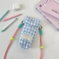 Close-up of blue quilted checkerboard camera bag with pink strap and neon accents - Light Blue Plaid