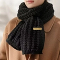 Thick black knitted scarf with handmade yellow label styled over a wool coat - Black Label Scarf