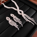 Primo piano del set collana di cristalli incrociati e orecchini lunghi con nappe - Set di 2 Pezzi Collana e Orecchini con Nappine a Croce