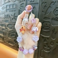 Handmade purple beaded phone strap featuring a cute capybara playing guitar and star charms - Capybara Beaded Charm / Random Hand-painted Beads / Purple