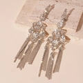 Macro shot of silver drop earrings with long rhinestone tassels and sparkling crystals - Water Drop Tassel Style / Silver