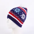Close-up of navy knit beanie featuring snowflake patterns and a soft white pom-pom - One Size / Kids Snowflake Navy Blue