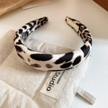 Dettaglio di un elastico in raso leopardato appoggiato su una borsa di lino testurizzato - Cerchietto Leopardo ad Arco Bianco (8#)