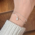 Detail showing the double-layer silver chain with a pearl charm on the model wrist - Silver Double Layer Pearl Stack (MY32751)