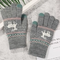Close-up of gray knitted gloves with reindeer pattern and touchscreen-friendly fingertips - Reindeer Grey