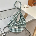 Detail of green and white plaid canvas hobo bag hanging on a modern chair - Green Black Grid