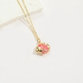 Gouden vis choker ketting met roze textuur op een minimalistisch wit display - Roze