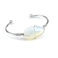 Macro shot of silver wire-wrapped white crystal stone on minimalist open cuff bracelet - Opal