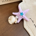 Dettaglio del fermaglio a stella marina con perla e conchiglia su legno antico - Stile Stella Marina Viola Conchiglia Perla / Viola