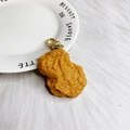 Detalle macro del llavero de nugget de pollo frito realista con cierre de langosta dorado - Nugget de pollo