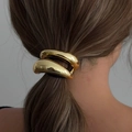 Polished golden curved metal hair ring for low ponytail holder on a model - Gold