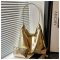 Dettaglio della borsa tote dorata lucida con pochette coordinata su un davanzale - Oro