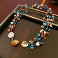Detailed close-up of multilayer shell bead necklace with orange and blue irregular stones - Necklace-Multicolor