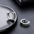 Vue macro de boucles d'oreilles huggie argentées avec pavé de zircons noirs et blancs - Argent Zircone Noir