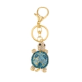 Golden turtle keychain with vibrant blue and clear rhinestones on white background - Blue