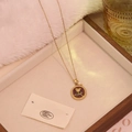 Dettaglio della collana vintage rosa dorata con piccola perla e accenti in smalto verde - Borgogna