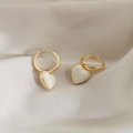 Détail de boucles d'oreilles plaquées or en forme de cœur sur fond de tissu doux - Boucles d'Oreilles Coeur Rétro - Blanc