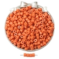 Glossy orange cylindrical acrylic beads displayed in a decorative silver bow bowl - Orange