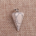 Polished hexagonal white turquoise pendant with natural black veins on brown fabric - Howlite
