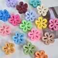 Flat lay of large flower hair claws in assorted matte candy colors on white background - Multicolor