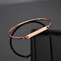 Minimalist rose gold stainless steel bangle featuring a flat rectangular bar for custom engraving - Rose Gold