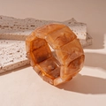 Macro shot of wide amber resin bracelet with marble texture on minimalist stone tiles - Light Coffee