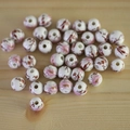 Runde Keramikperlen mit rosa Blumenmuster auf naturbelassenem Holzhintergrund - 8mm / Nr. 28-Rosa Floral